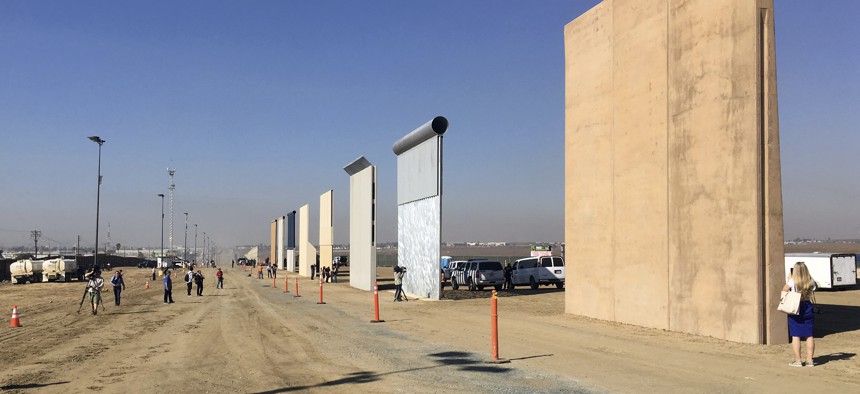 People look at prototypes of a border wall Thursday, Oct. 26, 2017, in San Diego. 