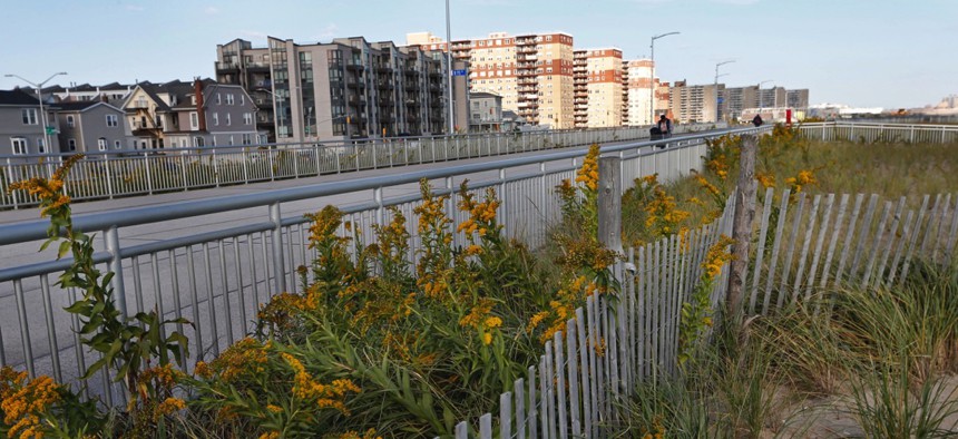 Five years after Superstorm Sandy, dune plantings border a broad concrete boardwalk separating residential buildings, left, from the beach in Rockaway Beach in the Queens borough of New York City.