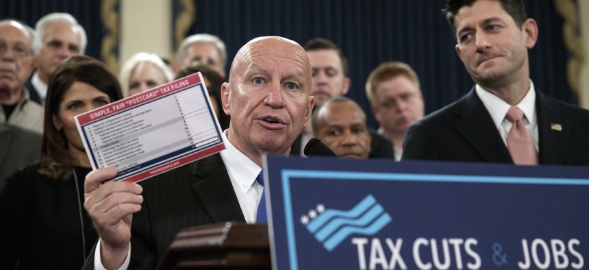 House Ways and Means Committee Chairman Kevin Brady, R-Texas, joined by Speaker of the House Paul Ryan, R-Wis., right, holds a proposed "postcard tax filing form" as they unveil the GOP's far-reaching tax overhaul, on Thursday, Nov. 2, 2017.