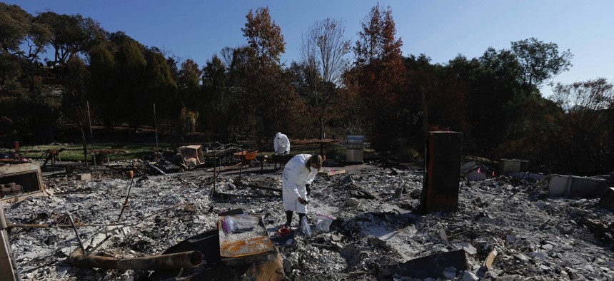 Shelly Rust, foreground, and her husband David search through the remains of their home destroyed by wildfires in Santa Rosa, Calif.