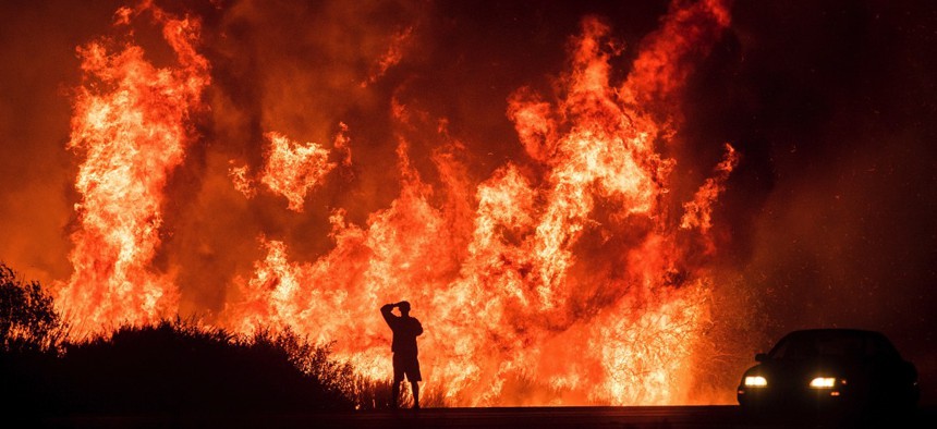 A motorists on Highway 101 watches flames from the Thomas fire leap above the roadway north of Ventura, Calif., on Wednesday, Dec. 6, 2017.
