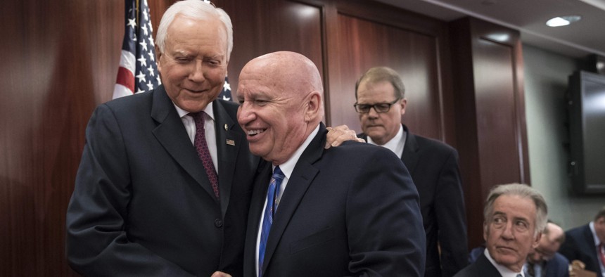 House Ways and Means Committee Chairman Kevin Brady, R-Texas, center, embraces Senate Finance Committee Chairman Orrin Hatch, R-Utah, left, on Capitol Hill in Washington, Wednesday, Dec. 13, 2017.