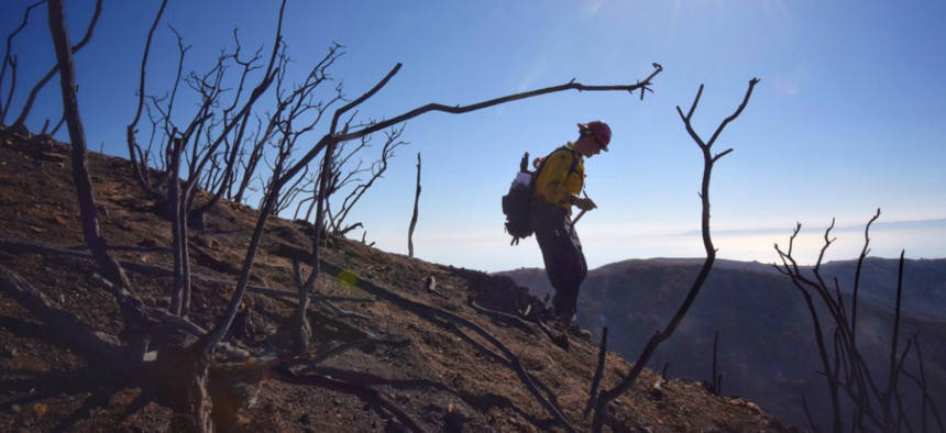 Santa Barbara County Fire Capt. Ryan Thomas hikes down steep terrain below East Camino Cielo while fighting the Thomas Fire on Dec. 19, 2017.