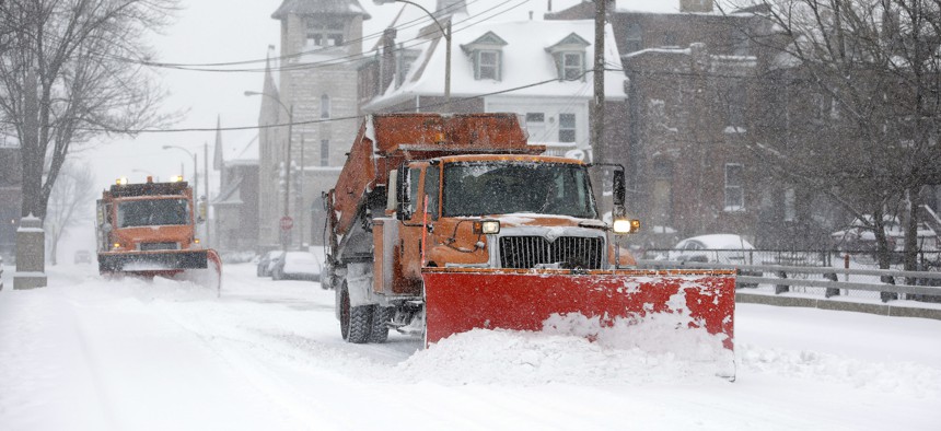 Snow plows attempt to clear the streets Sunday, Jan. 5, 2014, in St. Louis, Missouri