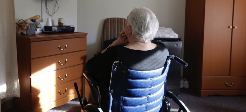 An elderly woman who has suffered abuse by a relative sits in her room in a retirement community in Mason, Ohio.