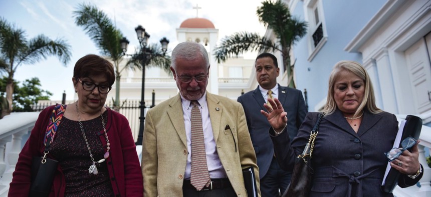 Puerto Rico Justice Secretary Wanda Vazquez-Garced, far right, walks with colleagues to a press conference in San Juan on Jan. 16 addressing the island's homicide surge.