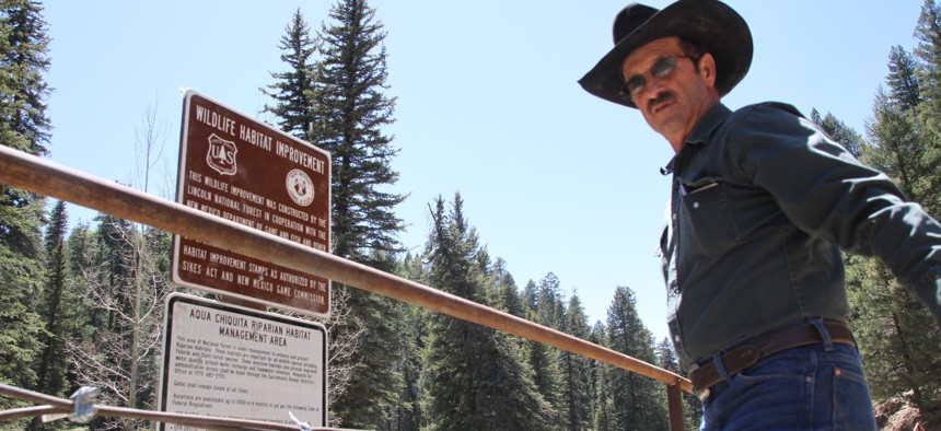 In this May 15, 2014, file photo, Otero cattle rancher association president Gary Stone inspects a newly posted warning sign in Weed, New Mexico. The forest service had closed off areas to prevent damage to New Mexico meadow jumping mouse's habit.