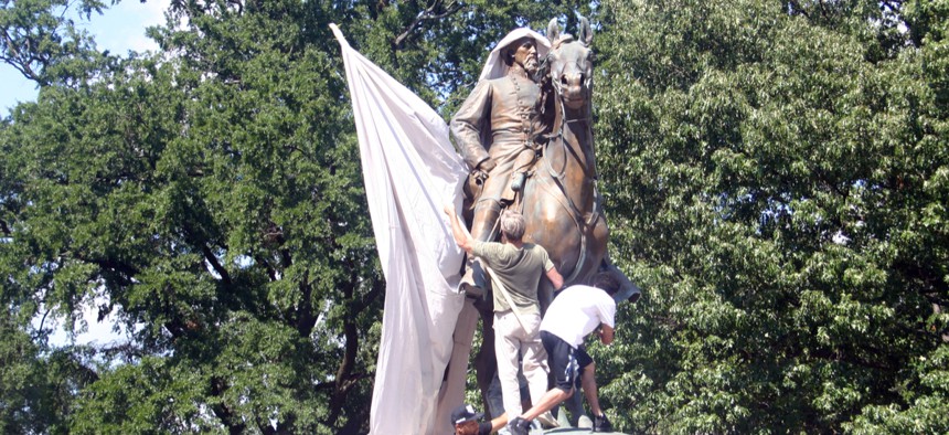 Protesters attempt to drape Nathan Bedford Forrest statue in a canvas calling for its removal in the #TakeEmDown901 campaign to dismantle confederate propaganda, August 19, 2017.