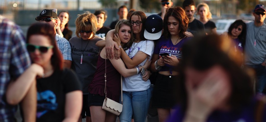 People comfort each other during a vigil for victims and survivors of a mass shooting in Las Vegas six months after the October violence.