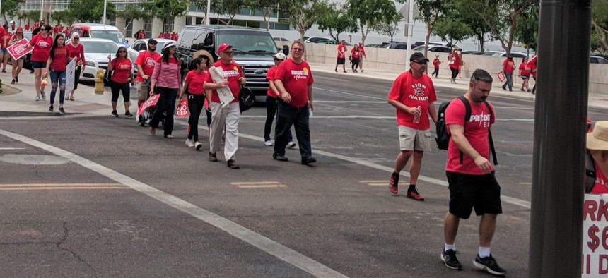 Arizona teachers dressed up in red shirts marching back from first day of their recent walkout.