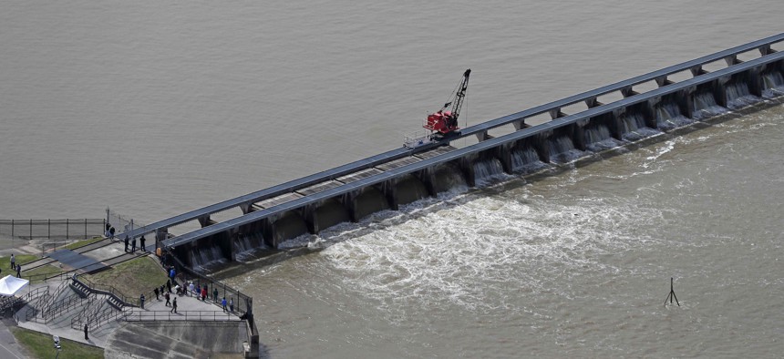 Workers open the gates of the Bonnet Carre spillway, a river diversion structure, which diverts water from the rising Mississippi River, left, to Lake Pontchartrain, in Norco, La., Thursday, March 8, 2018.