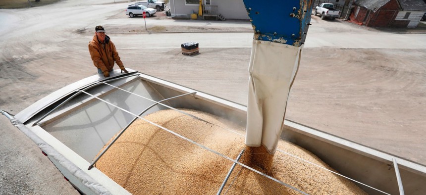 Terry Morrison watches as soybeans are loaded into his trailer at the Heartland Co-op on April 5 in Redfield, Iowa.