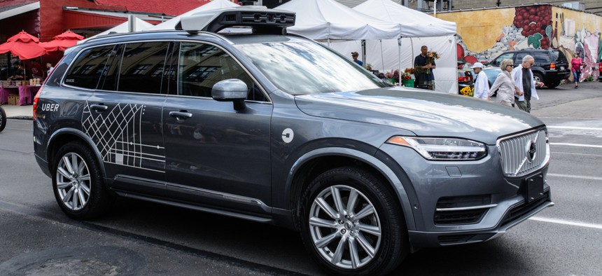 An Uber autonomous vehicle travels along Penn Avenue in Pittsburgh's Strip District.