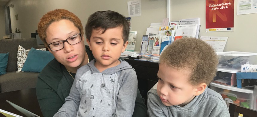 Victoria Castro reads to her son and his friend at the Liberty Family Success Center in Kearny, New Jersey. 