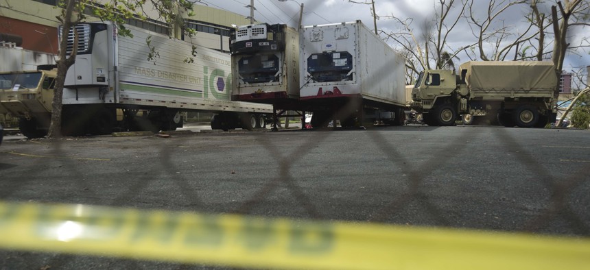 Three containers for holding corpses, right, are parked outside the Institute of Forensic Science, brought in to give support in the aftermath of Hurricane Maria in San Juan, Puerto Rico, Monday, Oct. 2, 2017.