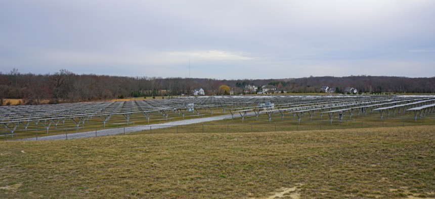 View of a large solar energy farm with solar panels lined up in a field in New Jersey.