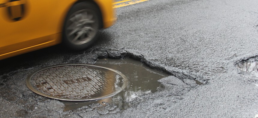 Taxi driving over big pothole in New York. 