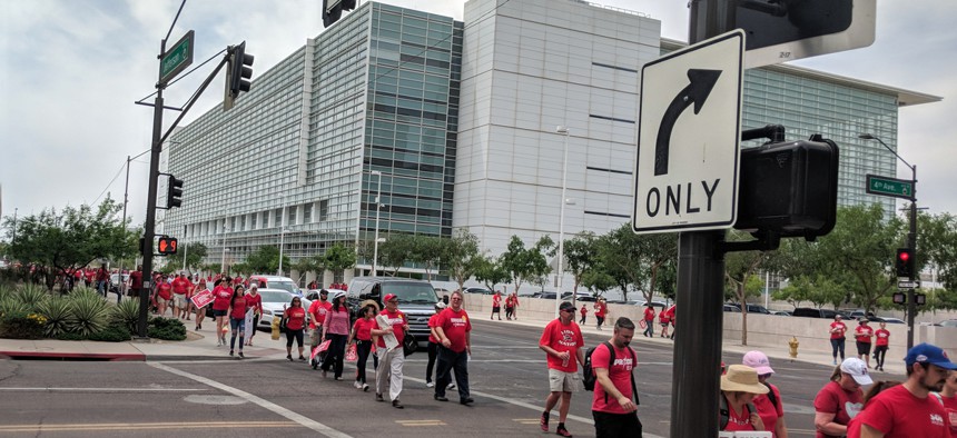 Arizona teachers in April dressed up in red shirts marching back from first day of Walk-Out known as RedForEd in Phoenix downtown along Jefferson Road.