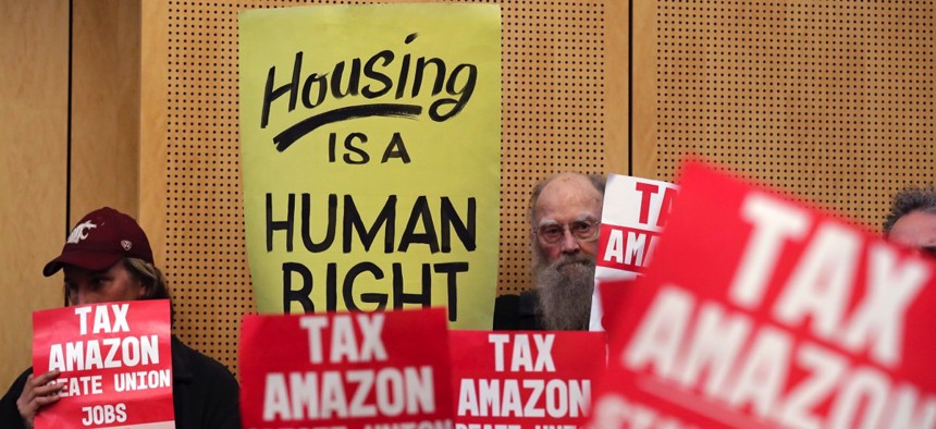 Members of the public look on at a Seattle City Council meeting before it voted in May to approve a tax on large businesses such as Amazon and Starbucks to fight homelessness.