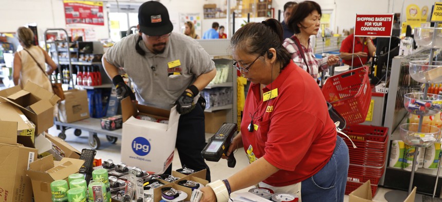 City Mill hardware store sales associates Frank Miller Gascon, left, Lisa Lavilla, fill a table up with duck tape, flashlights, and other hurricane supplies, Wednesday, Aug. 22, 2018, in Honolulu. 
