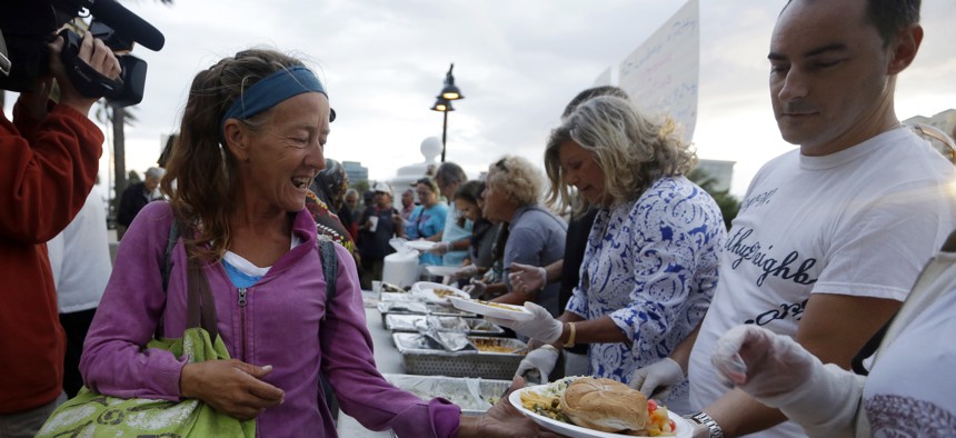 In this Nov. 5, 2014, file photo, members of the homeless community are served meals by advocates in Fort Lauderdale, Fla. 