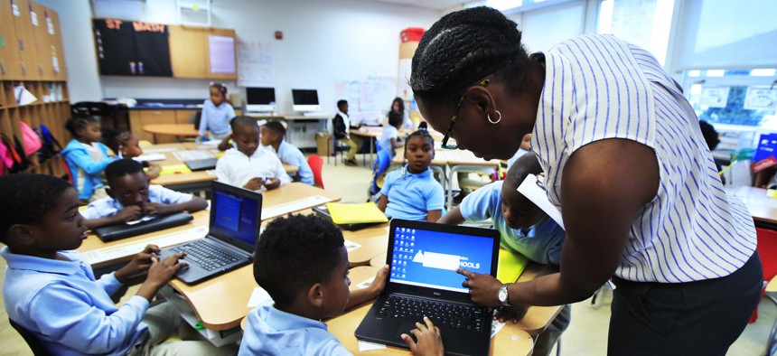 Teacher Denitra Henry, right, assists second grade student Jayden Bowie, with his computer during her math class at Turner Elementary School in southeast Washington, Tuesday, Aug. 29, 2017.