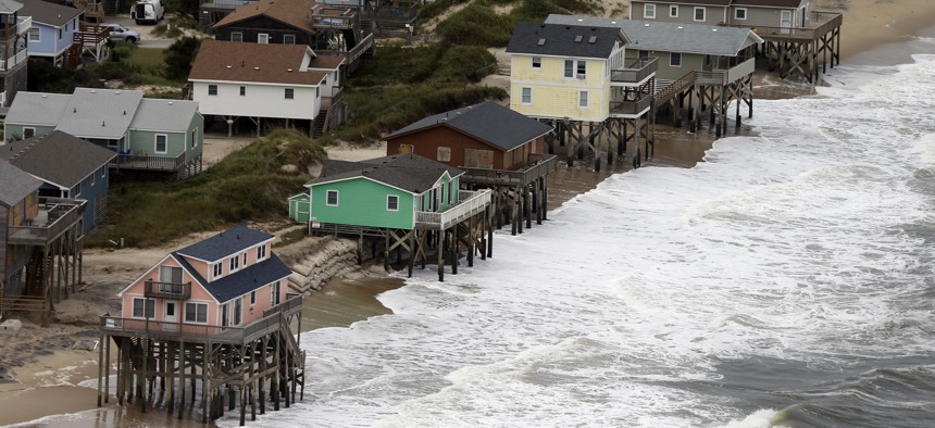 Oceanfront homes sit over the water as waves from hurricane Florence continue to pound the coast in Nags Head NC., Saturday, Sept. 15, 2018. 