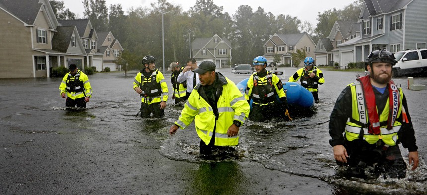 Members of the North Carolina Task Force urban search and rescue team wade through a flooded neighborhood looking for residents who stayed behind as Florence continues to dump heavy rain in Fayetteville, N.C. on Sunday.