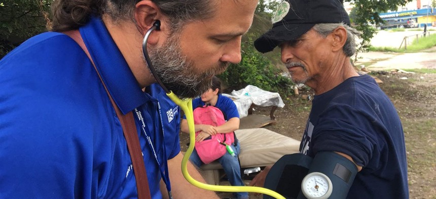 Physician assistant Joel Hunt treats Raul Reyes, 59, at a homeless encampment outside of downtown Fort Worth, Texas.
