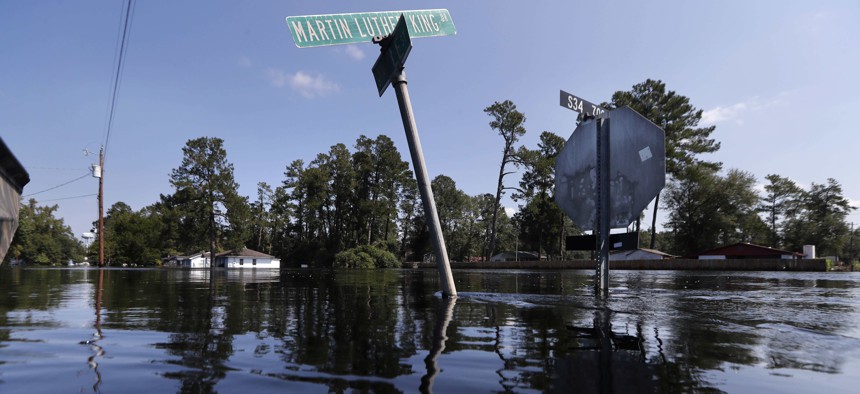 Street signs protrude through floodwaters in the aftermath of Hurricane Florence in Nichols, S.C., Friday, Sept. 21, 2018. Virtually the entire town is flooded and inaccessible except by boat, just two years after it was flooded by Hurricane Matthew.