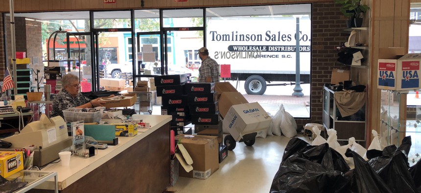 Employees at Tomlinson Department Store take all the merchandise out of the store in Georgetown, South Carolina, on Monday ahead of expected flooding.