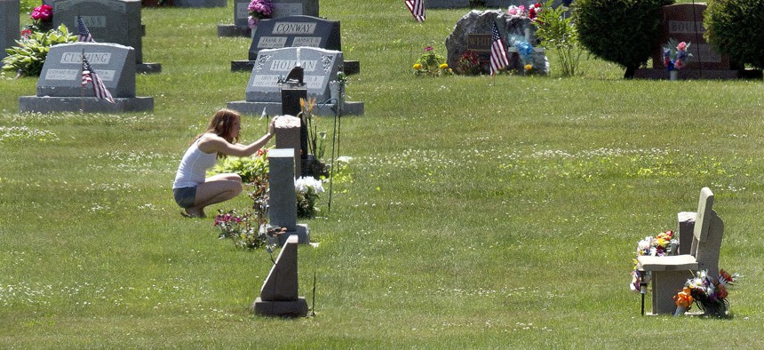 In this June 17, 2016 file photo, Erika Marble visits the gravesite of Edward Martin III, her fiancé and father of her two children, in Littleton, N.H. The 28-year old died Nov. 30, 2014, from an overdose of the opioid fentanyl. 