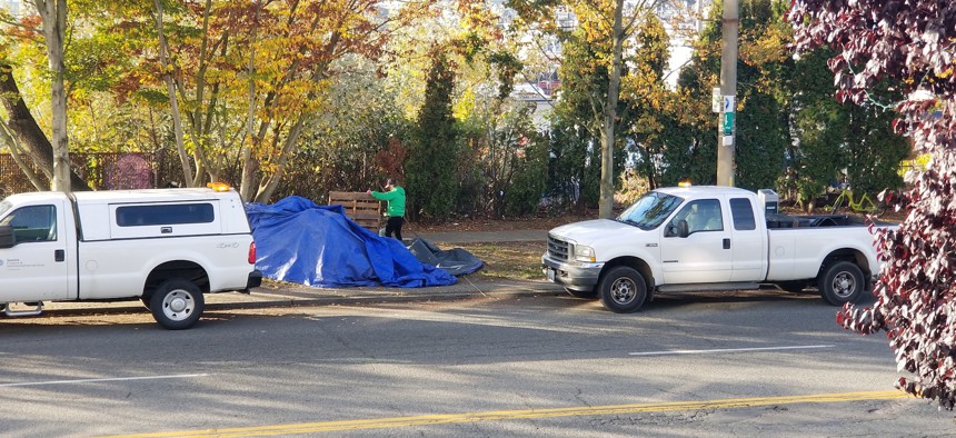 A city work crew in Seattle clears a homeless camp along NW Market Street in the Ballard neighborhood on Thursday morning.