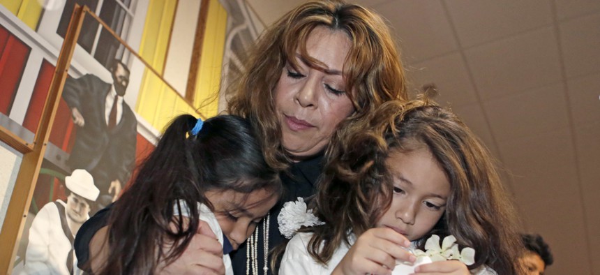 A woman comforts two children under her legal guardianship in Miami last year. One in five children being raised by extended family members live in an immigrant household, a new report shows.