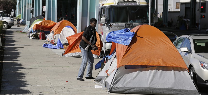 In this Feb. 23, 2016 file photo, a man stands outside his tent on Division Street in San Francisco.