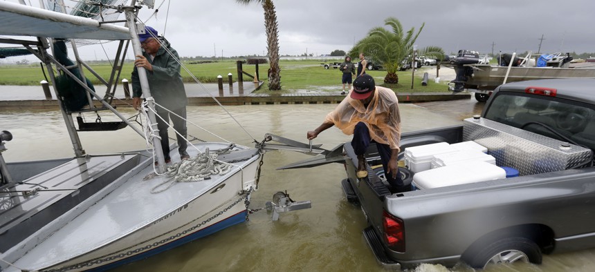 Tony Danos, left, and C.J. Johnson pull a shrimp boat out of the water, in anticipation of Tropical Storm Karen, at Myrtle Grove Marina in Plaquemines Parish, La., Friday, Oct. 4, 2013.