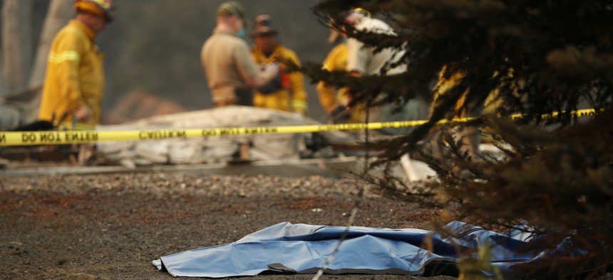 A bag containing human remains lies on the ground as officials continue to search at a burned out home at the Camp Fire, Sunday, Nov. 11, 2018, in Paradise, Calif. 