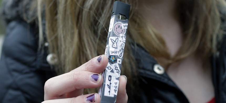 In this Wednesday, April 11, 2018 photo, an unidentified 15-year-old high school student displays a vaping device near the school's campus in Cambridge, Mass.