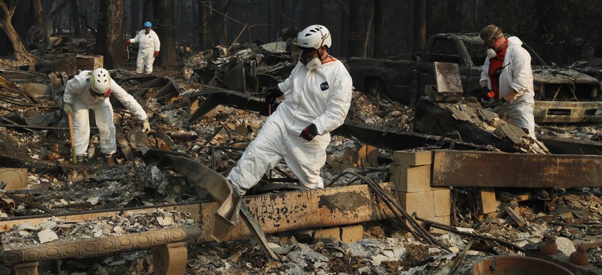 Search and rescue personnel search a home for human remains in the aftermath of the Camp fire in Paradise, Calif. on Friday.