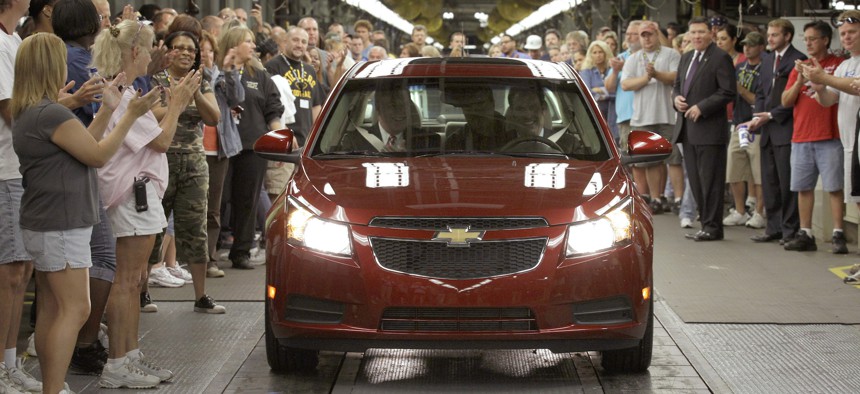 In this file photo taken Sept. 8, 2010, General Motors workers cheer as the first Chevrolet Cruze compact sedan off the assembly line, at the GM factory in Lordstown, Ohio.