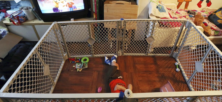 In this July 28, 2017, photo, Alexander, 2, a disabled foster child, lies on a mat in a playpen at his foster home in Philadelphia. 