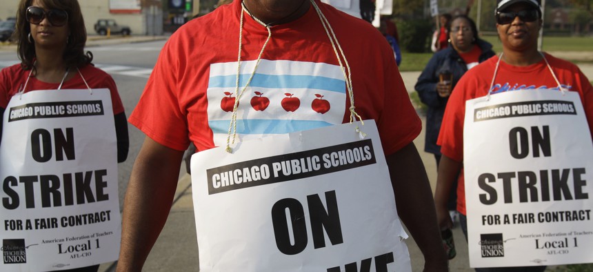 In this Sept. 17, 2016, file photo, teachers picket outside Morgan Park High School in Chicago. 