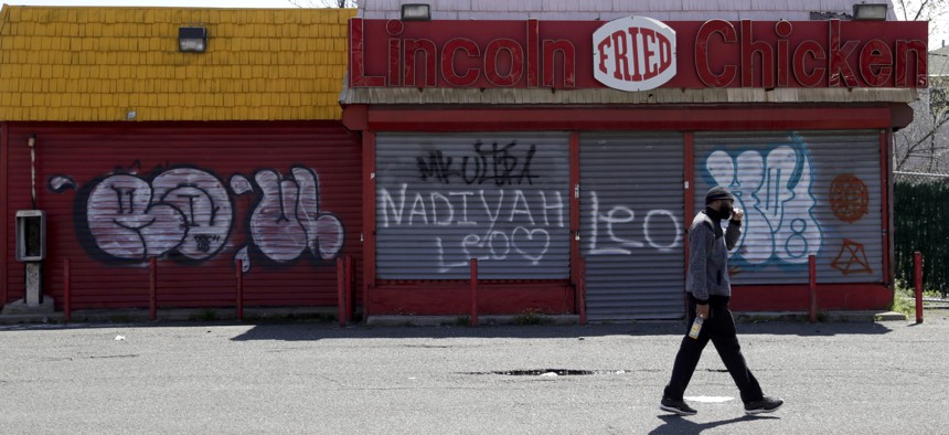 In this April 26, 2018, photo a man walks by a closed restaurant along Bergen Street in an Opportunity Zone in Newark, N.J. 