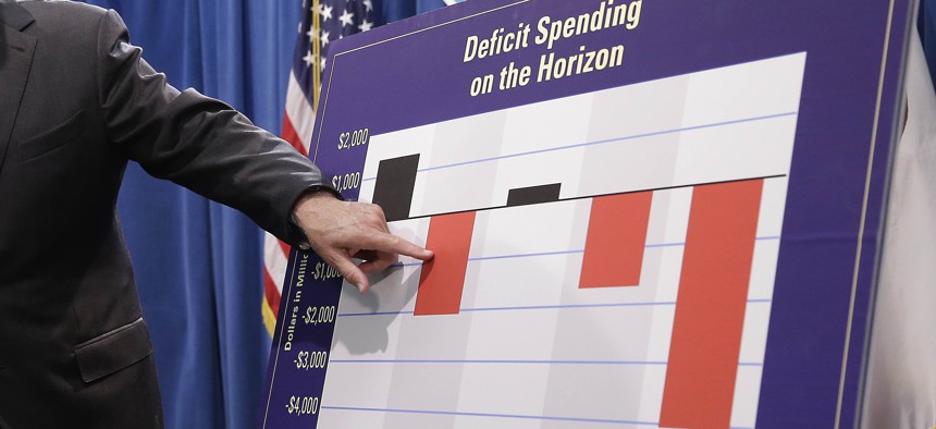  In this May 13, 2016, file photo, California Gov. Jerry Brown gestures to a chart showing possible future deficit spending as he discusses his revised 2016-17 state budget plan in Sacramento, Calif. 