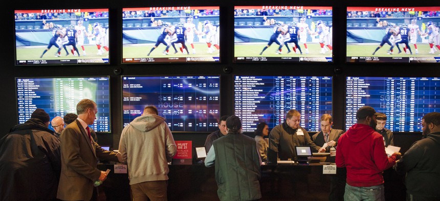 In this Thursday, Dec. 13, 2018, file photo, gamblers place bets in the temporary sports betting area at the SugarHouse Casino in Philadelphia.