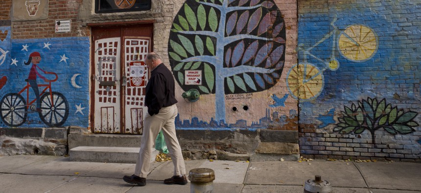 A man passes a mural at Rockaway Brewing Company in Long Island City, a part of Queens in NYC that is a longtime industrial and transportation hub that has become a fast-growing neighborhood of riverfront high-rises and redeveloped warehouses.