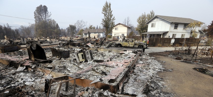 Houses remain standing and with little damage in view of others that were destroyed in a wildfire several days earlier, Tuesday, Sept. 15, 2015, in Middletown, Calif. 