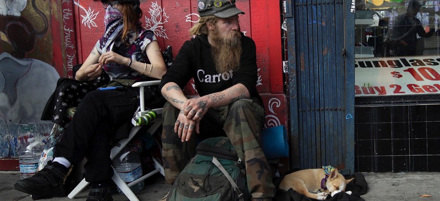Homeless man Stormy Nichole Day, left, sits on a sidewalk on Haight Street with Nord and his dog Hobo on Oct. 1, 2018, in San Francisco.