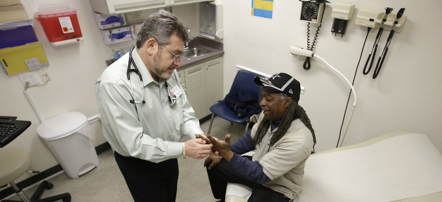 A doctor examines a Medicaid patient at a clinic in Sacramento, California. The state is one of at least 10 exploring whether to allow residents to pay premiums to "buy in" to Medicaid.
