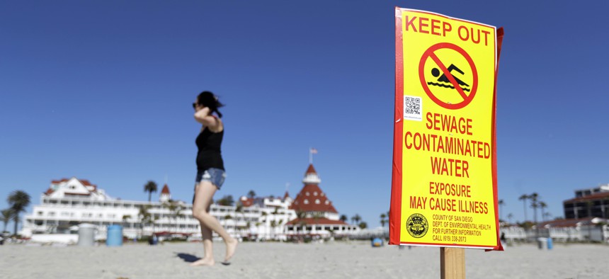 A sign warns of sewage contaminated ocean waters on a beach in front of the iconic Hotel del Coronado on Wednesday, March 1, 2017, in Coronado, Calif. 